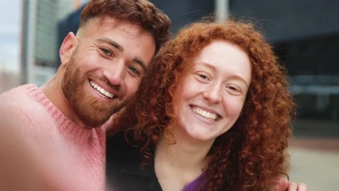 Happy redhead twins having fun doing video call with mobile phone outdoor Stock Footage 182580269