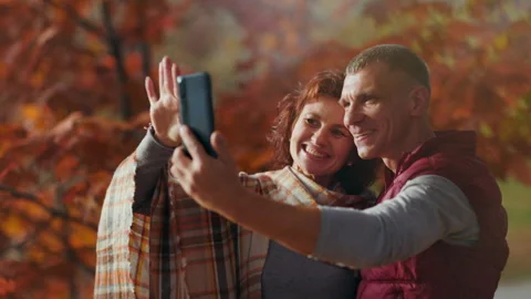 Happy romantic couple in park using phone and taking selfie Stock Footage 252748344
