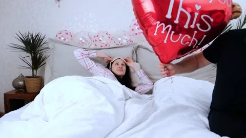 Happy romantic young couple, guy with heart-shaped balloon. Valentine's Day cele Stock Footage 169521956