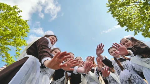 Happy Russian female graduates hug and wave their hands on graduation day. Stock Footage
