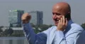 Happy Sales Agent Outside Office Building Receiving Good News on Mobile Phone 4k or 4k+ Resolution