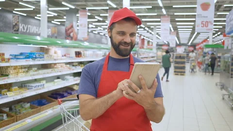 Happy salesperson using a digital tablet in supermarket Stock Footage 93545396