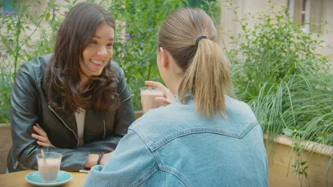Happy Same Sex Female Couple Meeting And Sitting Outdoors At Coffee Shop Stock Footage