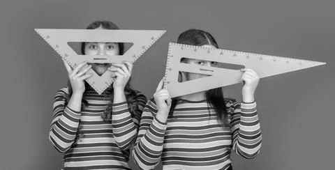 Happy school students hold math tool of triangle Stock Photos