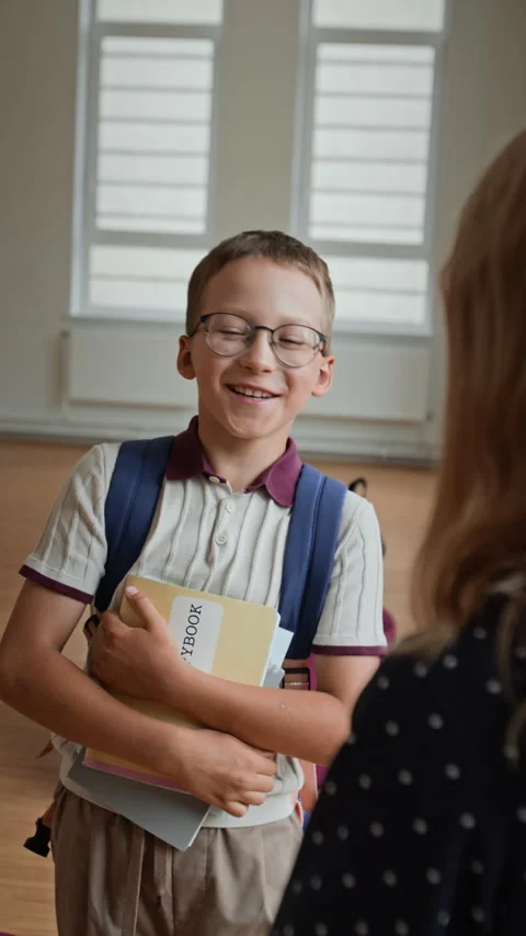 Happy Schoolboy with Backpack Holding Books Talking in Classroom Stock Footage 345245825