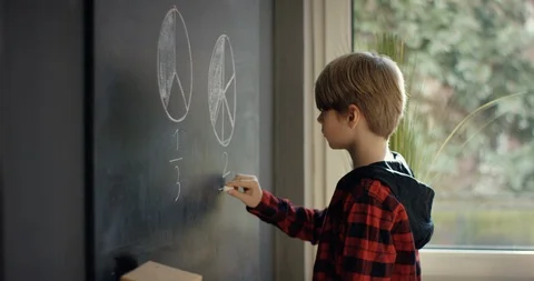 Happy schoolboy on math class writing on blackboard Stock Footage 128900061