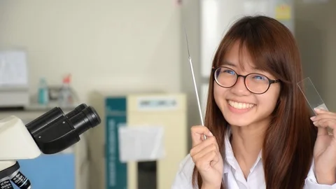 Happy scientist show loop and microscope slide on her hands for science lab Stock Footage 87446584