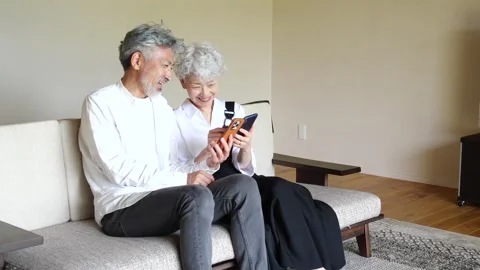 Happy Senior Asian Couple Using Smartphones Together at Home Vídeos de archivo 344088065