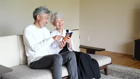 Happy Senior Asian Couple Using Smartphones Together at Home Stock-Footage 344088098