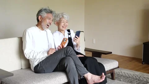 Happy Senior Asian Couple Using Smartphones Together at Home 스톡 동영상 344088167