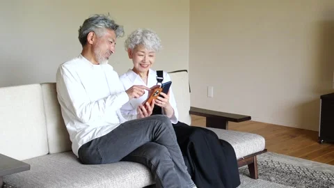 Happy Senior Asian Couple Using Smartphones Together at Home Stock-Footage 344088175