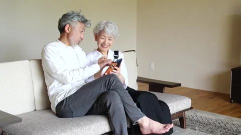 Happy Senior Asian Couple Using Smartphones Together at Home Stock-Footage 344088212