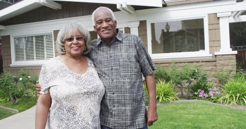 Happy senior black couple smiling in front of new home Stock Footage