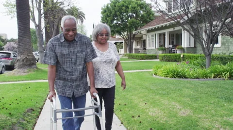 Happy senior black couple walking together with walker Stock Footage