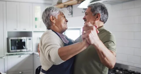 Happy senior couple dancing in kitchen Stock Footage 344534339