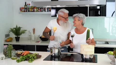 Happy senior couple dancing while cooking together Stock Footage 137440528