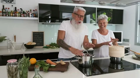 Happy senior couple dancing while cooking together at home Stock Footage 137440601