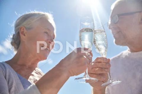 Happy senior couple drinking champagne outdoors Stock Photos