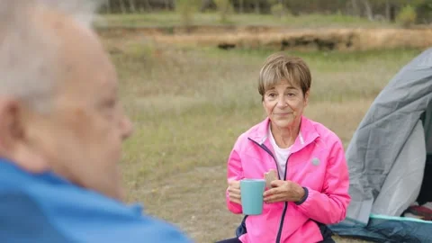 Happy senior couple eating while camping in mountain forest - Elderly nature Stock Footage 170508732