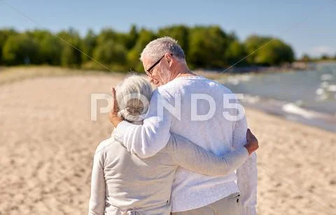 Happy senior couple hugging on summer beach Stock Photos