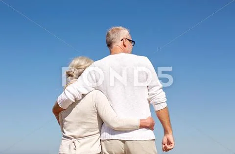 Happy senior couple hugging on summer beach Stock Photos