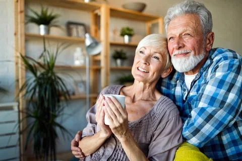Happy senior couple in love hugging and bonding with true emotions at home Stock Photos