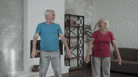 Happy senior couple performing exercise at home. Two positive couple full of Stock Footage 142018657