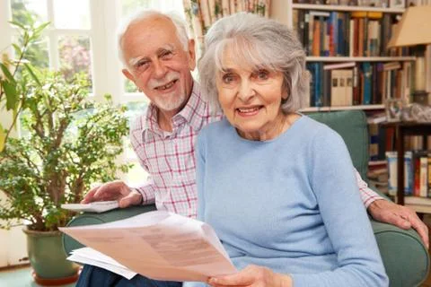 Happy Senior Couple Reviewing Finances At Home Stock Photos