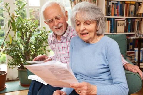 Happy Senior Couple Reviewing Finances At Home Stock Photos