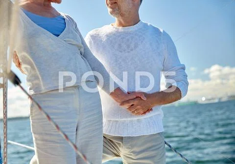Happy senior couple on sail boat or yacht in sea Stock Photos