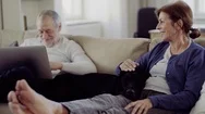 A Happy Senior Couple Sitting On A Sofa Indoors With A Pet Dog At Home, Using Stock Footage