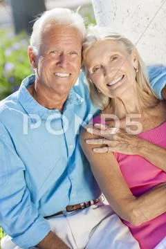 Happy senior couple smiling outside in sunshine Stock Photos