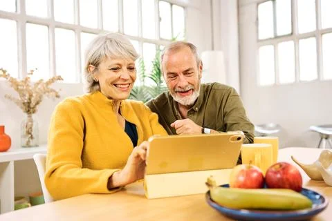 Happy senior couple using digital tablet at home Stock Photos