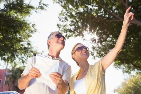 Happy senior couple using the map and looking Fotos Stock