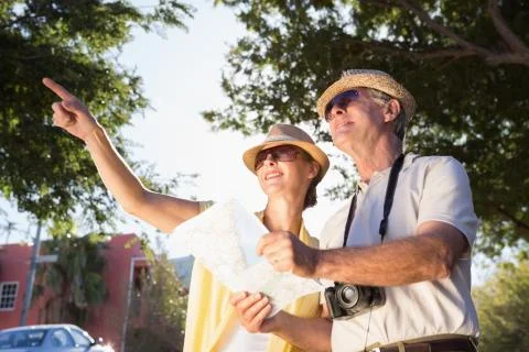 Happy senior couple using the map and looking Fotos Stock