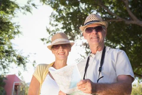 Happy senior couple using the map and looking at camera Fotos Stock