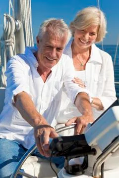 Happy senior couple using satnav gps on a sail boat Stock Photos