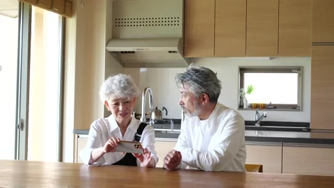 Happy Senior Couple Using Smartphone Together at Home Stock Footage 344087755