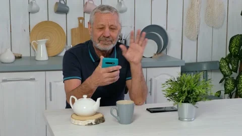 Happy senior elderly beared man holding smart phone, video calling online Stock Footage 170779462