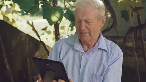 Happy senior emotionaly using the tablet in the garden. 4K Stock Footage