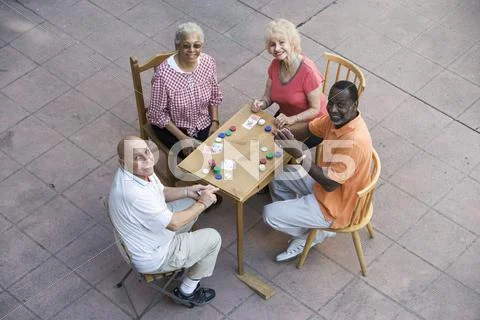 Happy Senior Friends Playing Cards Stock Photos