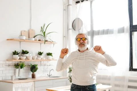 Happy senior man dancing while listening to music with headphones, copy space Stock Photos