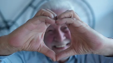 Happy Senior Man Forms a Heart Shape with His Hand Stock Footage 333200622
