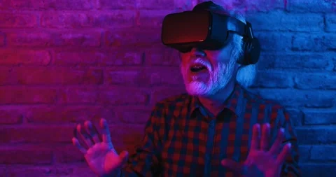 Happy senior man having fun using augmented reality goggles 库存影片 174243679