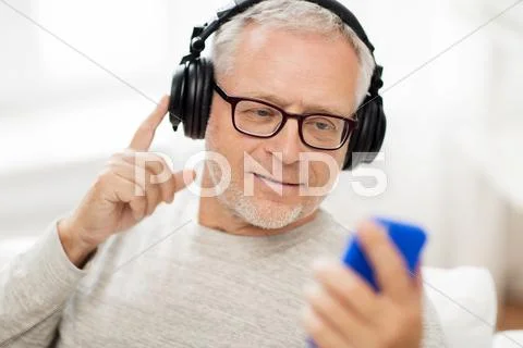 Happy senior man with smartphone and headphones Stock Photos