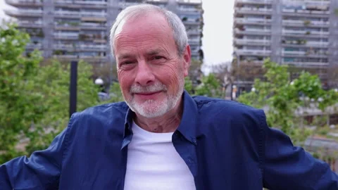 Happy senior man smiling at camera standing over urban background Stock Footage 276804481