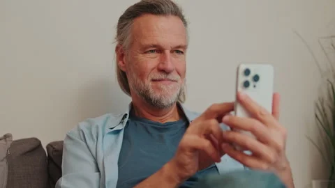 Happy Senior Man Using Mobile Phone at Home Stock Footage 337104190