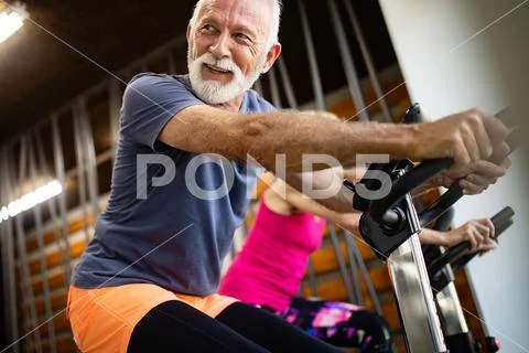 Happy senior people doing indoor biking in a fitness club Stock Photos