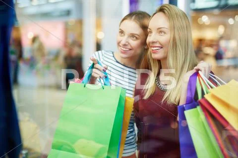 Happy shopper pointing at something in shop-window Stock Photos