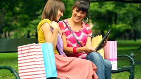 Happy shopping friends with tablet computer in the park, steadycam shot Stock Footage 8678798